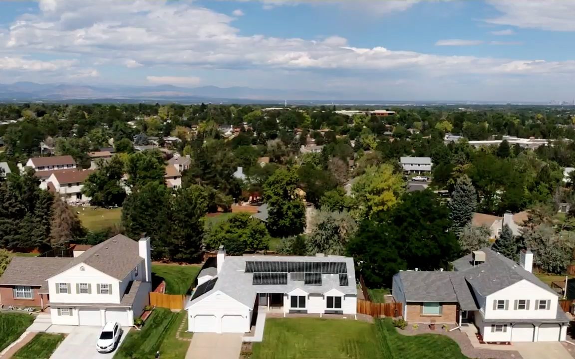 Asphalt roofs, one with solar, suburbs below the front range